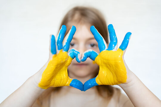 Love Ukraine concept. hands in heart form painted in Ukraine flag color - yellow and blue.No war, child ask for help. Selecrive focus. 