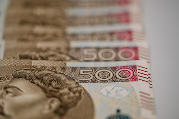 Zdjęcie przedstawiające plik banknotów 500 zł w różnych perpektyw