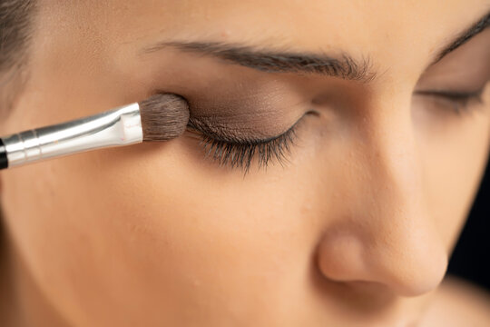 woman applying eye shadow with a brush