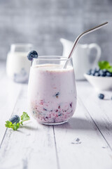 blueberry or mixed berry milk shake in a glass served for refreshment, healthy eating, dieting, morning breakfast . High quality photo