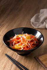 Healthy Chinese cabbage salad in bowl on wooden table