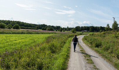 Woman walking on a path at the Swedish countryside