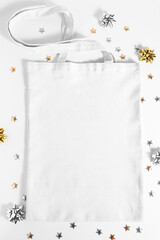 Textile bag in white color on a wooden table, top view. Mockup with copy space, blank template.