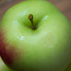 A large green apple, a close-up shot. A wet apple.