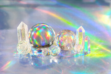 quartz crystal and balls on abstract holographic background close up. spiritual healing crystal...