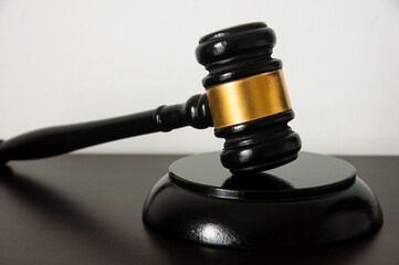 Straight view of lawyer gavel on wooden table with white background.