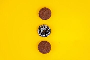 chocolate donuts on a yellow background. lie in the background. space for your advertisement