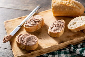 Toasted bread with pork liver pate on wooden table	