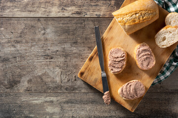 Fototapeta na wymiar Toasted bread with pork liver pate on wooden table. Top view. Copy space