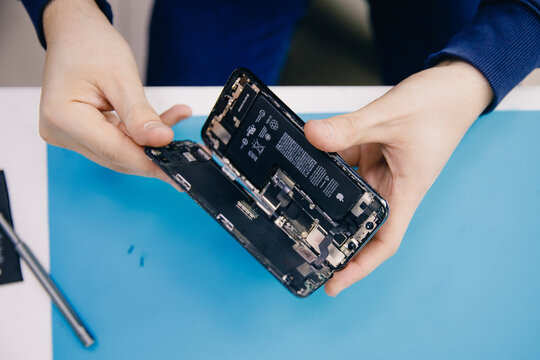 RUSSIA - February 20, 2022: Repair iPhone apple broken phone screen and replace used rechargeable batteries for recycling