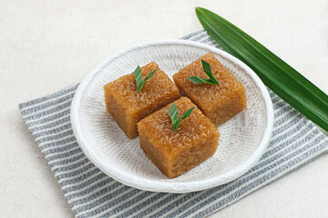 Wajik, traditional Indonesian snack made from steamed sticky rice, palm sugar, coconut milk, and pandan leaves. Selected focus.
