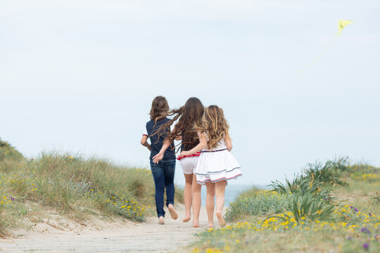 Niños corriendo en verano hacia la playa. 
Concepto de diversión infantil en vacaciones de verano.