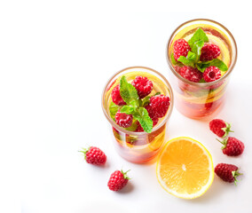 Detox fruits infuse water with ice, raspberries, lemon, mint on wooden background. Refreshing summer drinks, selective focus.