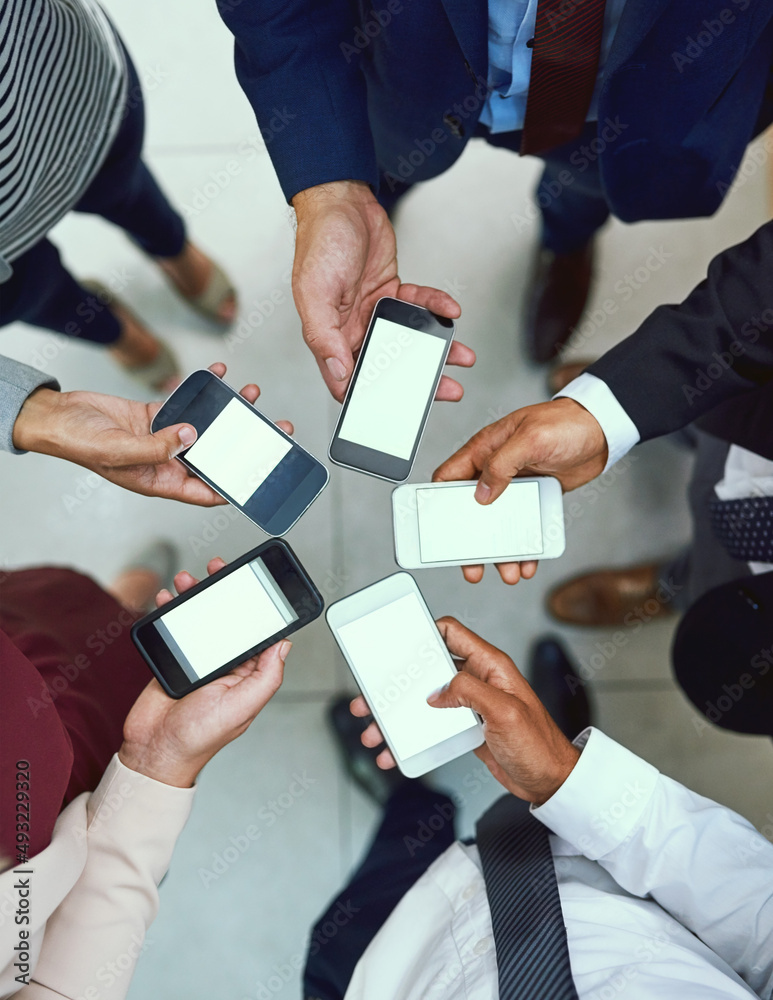 Poster its one connected workplace. high angle shot of a group of unrecognisable businesspeople using their