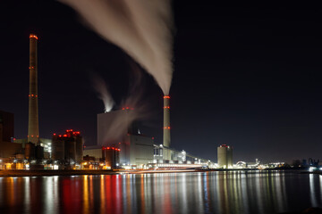 Large coal-fired power plant at night with reflection in the Rhine.
