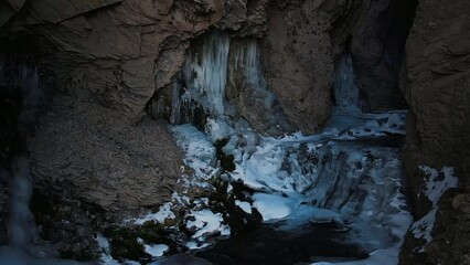 The stream of the mountain river in a narrow gorge, covered with ice - Powered by Adobe
