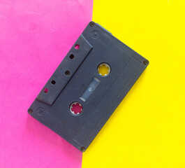 Black Audio cassette on a pink yellow creative background
