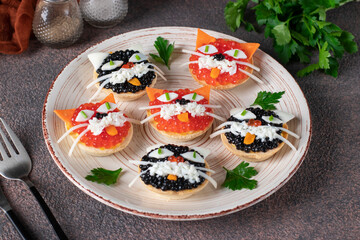 Tartlets Kittens with cheese, egg and caviar on a round plate on brown background