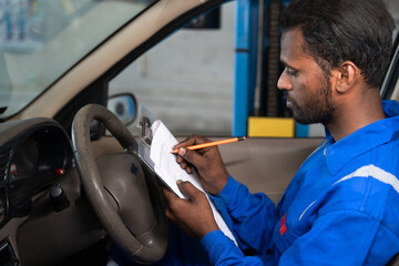 Car Mechanic writing down problems of car while at repair or maintenance service for budget...