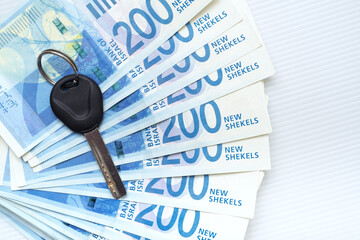 Key of the house on israeli shekels banknotes lay in a fan. Cash money illustrate rent and bay real estate in Israel