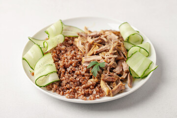 Boiled beef meat, buckwheat and cucumber in a plate on the table. Diet nutrition