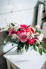 Beautiful wedding bouquet of protea, dahlia, rose, eucalyptus flowers on a light wooden background. - 493239300