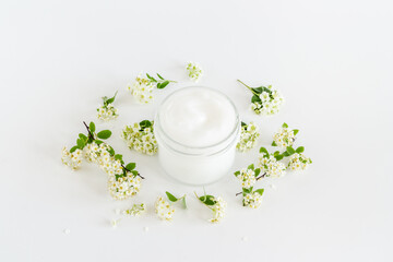 Obraz na płótnie Canvas Herbal facial cream cosmetic for skin care with white flowers