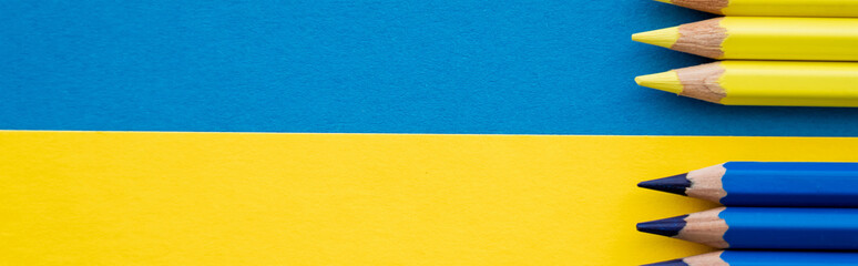 Top view of yellow and blue color pencils on ukrainian flag, banner.