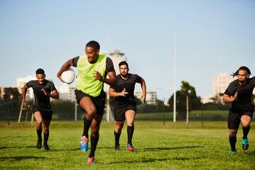 They cant keep up. Full length shot of a diverse group of sportsmen playing a game of rugby during the day. - obrazy, fototapety, plakaty