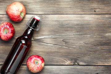 Apple juice in a bottle. Apple cider vinegar, salad dressing on wooden background with copy space top view. Natural products, healthy homemade food. Fermented food