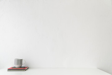 Office table, empty desk with supplies and white wall copy space.	
