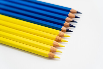 Obraz premium Close up view of yellow and blue color pencils on white background.