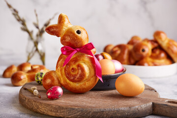 Buns made from yeast dough in a shape of Easter bunny, and colored eggs. Traditional Easter symbols and food.