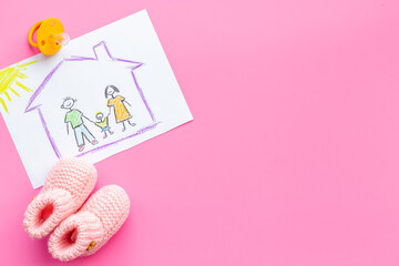 Childrens pencil drawing of family with booties. Adoption concept. Top view