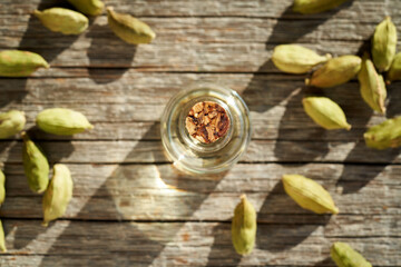 Fototapeta na wymiar A bottle of aromatherapy essential oil with cardamom seeds
