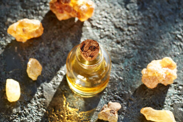 A bottle of frankincense essential oil with frankincense resin crystals