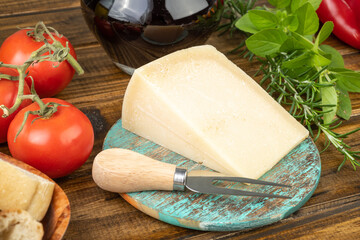 Parmesan cheese, tomatoes, olive oil, wine, bread and herbs over wooden table. Mediterranean food