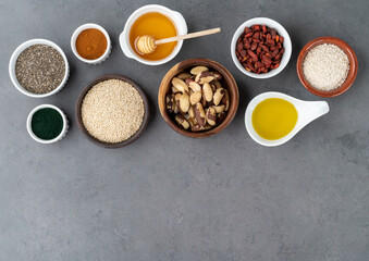 Assorted superfoods over stone background with copy space. Chia, quinoa, oat, linseed, honey, spirulina and others