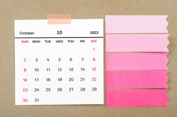 October 2022 calendar with blank adhesive note paper on brown background.