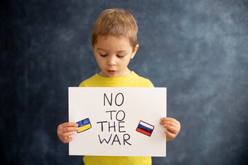 Young blond child, holding sign in support to peace, no war wanted, kid wishing peaceful life