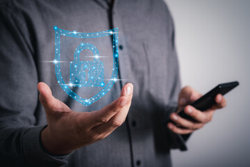 digital graphic Shield lock button and personal information icons appeared while man using smart mobile phone on dark background. Cyber security, data protection, business privacy technology concept.