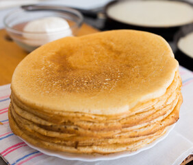 process of baking pancakes in pans on kitchen stove. stack of hot pancakes