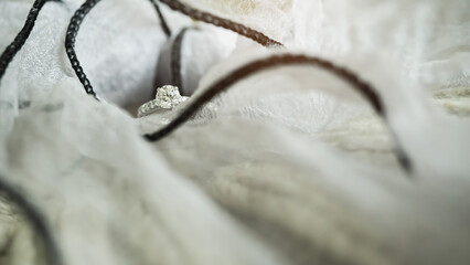 Close up of an elegant diamond ring on gray knit background. love and wedding concept. Soft and selective focus.