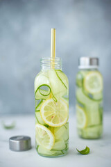 detox water with cucumber, lemon and mint in a tall glass bottle