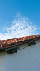 Tejado de tejas de barro en casa rural y nube en el cielo