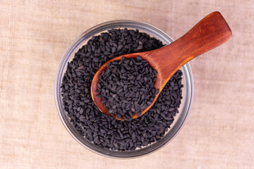 Black sesame seeds in a plate. Flat lay.