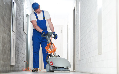 worker with machine cleaning floor in residence hall