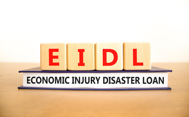 EIDL economic injury disaster loan symbol. Words EIDL economic injury disaster loan on cubes on book. Beautiful white background. Copy space. Business EIDL economic injury disaster loan concept.