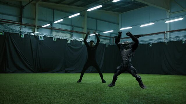 Actor in motion capture suit performing some stunt moves next to a game character. Motion capture is an unparalleled method for making animated characters move more realistically