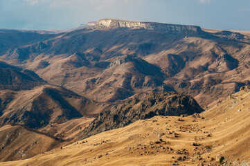 Fototapeta na wymiar Mountain valley and creeping velvet shadows of Bermamyt plateau.